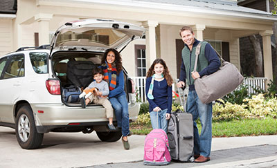 family with luggage sitting in back of suv